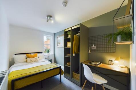 A well-lit and tidy bedroom featuring a stylish...