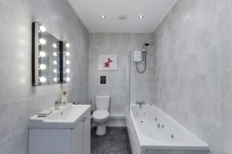 A spacious and stylish bathroom featuring a rel...