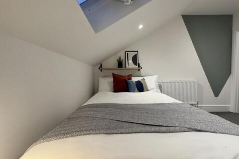 A beautifully arranged double bedroom with mode...