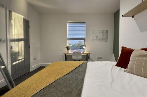 A bright and inviting double bedroom with a coz...