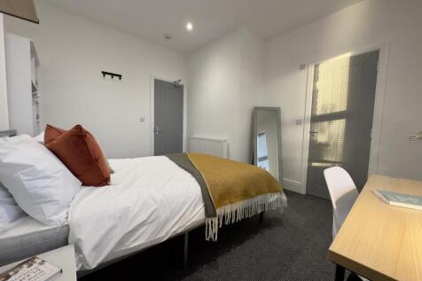 A bright and inviting double bedroom with moder...