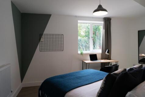 A stylish double bedroom featuring ample natura...