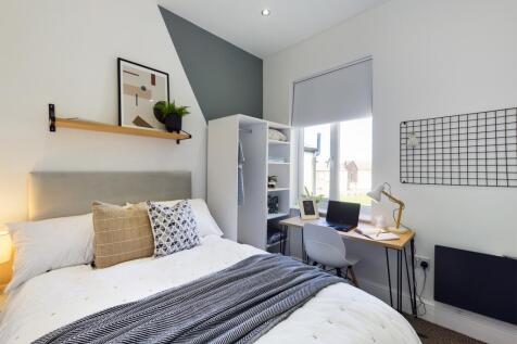 A bright and stylish double bedroom featuring a...