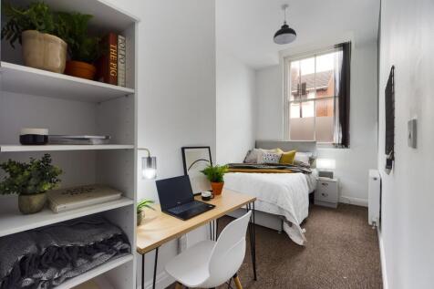 A bright and inviting double bedroom with a stu...