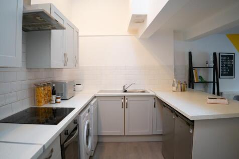 A bright and modern kitchenette with ample coun...