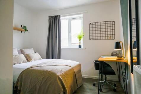 A bright and inviting double bedroom with a coz...