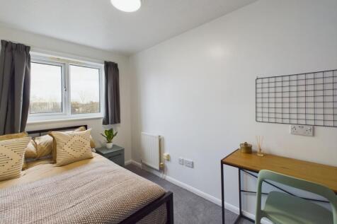 A bright and inviting double bedroom with a coz...