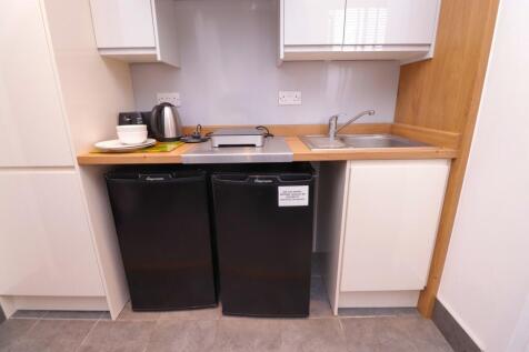 A sleek and tidy kitchenette featuring modern a...