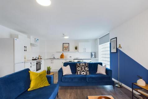 A bright and modern living room featuring two c...