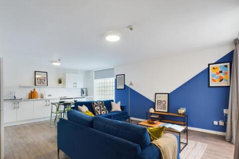 A modern, well-lit living room featuring a comf...