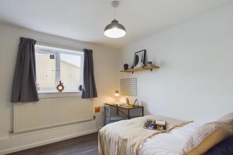 A bright and welcoming bedroom featuring a neat...