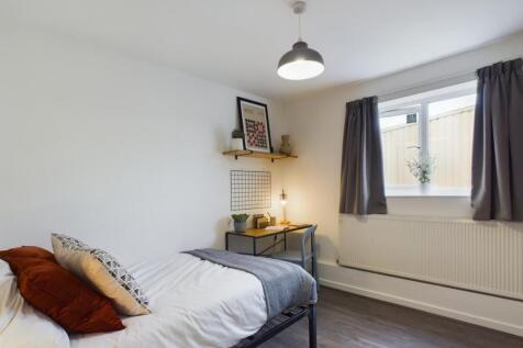 Bright and inviting bedroom featuring a cozy be...