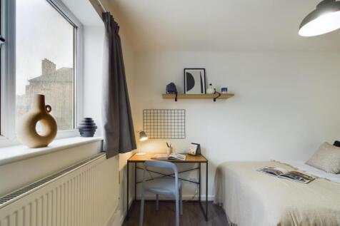 A cozy and well-maintained bedroom featuring a ...