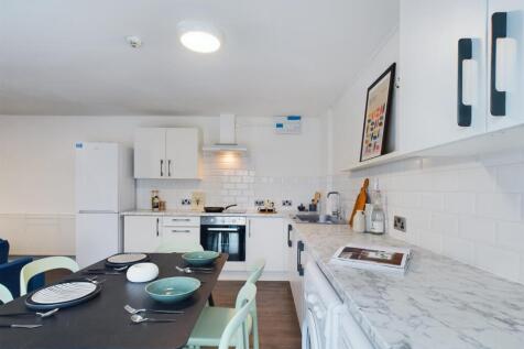 Bright and modern kitchen with ample storage, w...