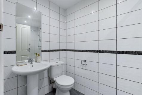 A bright and modern bathroom featuring sleek ti...