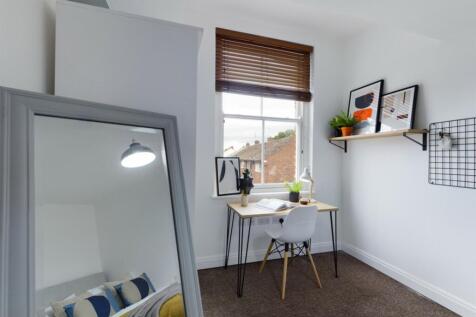 A bright and tidy double bedroom with a cozy de...