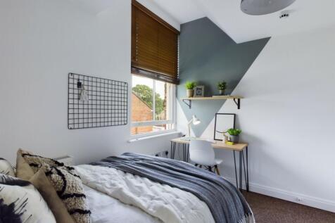 A bright and stylish double bedroom featuring a...