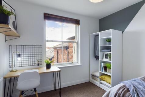 A bright and inviting double bedroom with a sty...