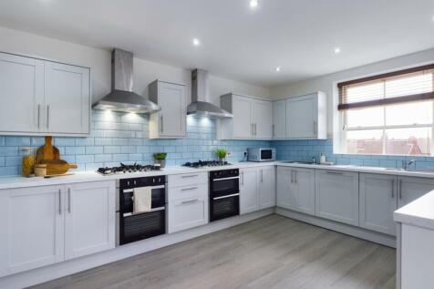 A bright and modern kitchen featuring sleek cab...