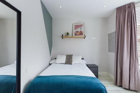 A spacious and modern double bedroom featuring ...