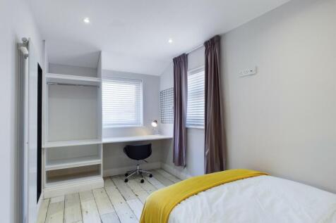 Bright and tidy bedroom with a comfortable bed,...