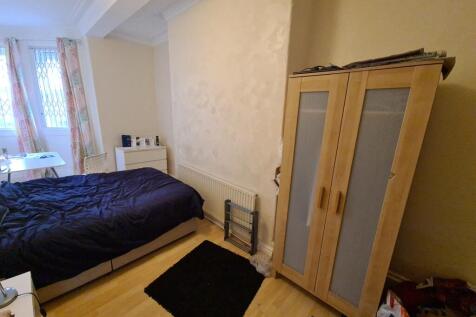 A cozy bedroom featuring a neatly made bed plac...