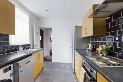 A modern and tidy kitchen featuring ample count...