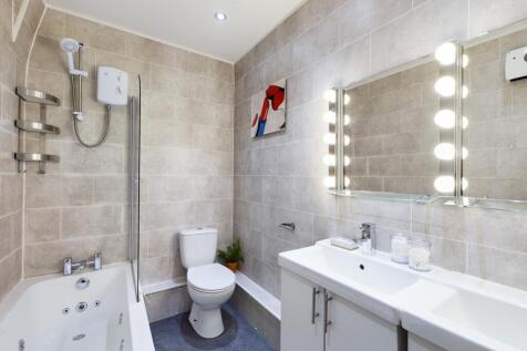 A spacious and modern bathroom featuring a rela...