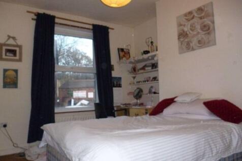 A spacious master bedroom featuring a large bed...