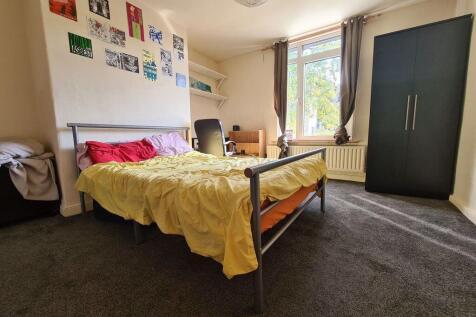 A spacious double bedroom featuring a comfortab...