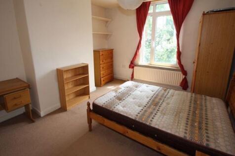 A comfortable student bedroom featuring a woode...