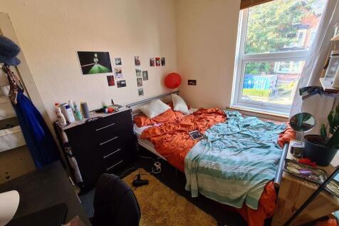 A cozy bedroom featuring a double bed with colo...