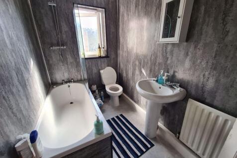 A well-maintained bathroom featuring a bathtub,...