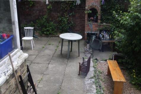 A tidy outdoor garden area with paving, a few c...