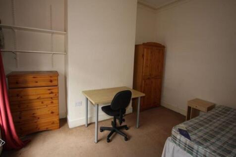 A cozy single bedroom featuring a bed, a wardro...