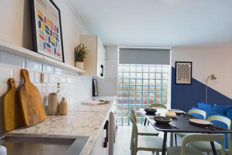 A modern and stylish kitchenette with ample spa...