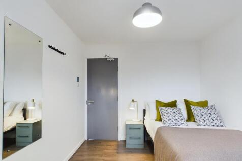 A bright and clean double bedroom featuring sty...