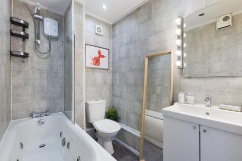 A modern and spacious bathroom featuring a luxu...