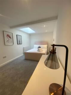 A bright, spacious master bedroom featuring a l...