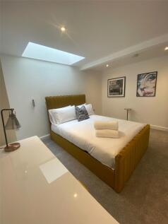 A spacious, bright master bedroom featuring a m...