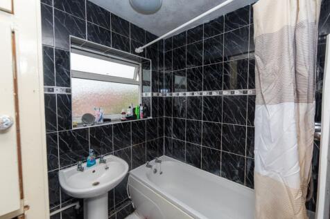 A small, tidy bathroom with black marble tiles,...