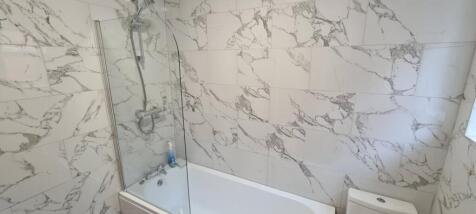 Modern bathroom with elegant marble-look wall t...