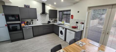 Modern kitchen with sleek dark cabinetry, large...