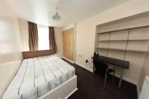 A cozy single bedroom featuring a comfortable b...