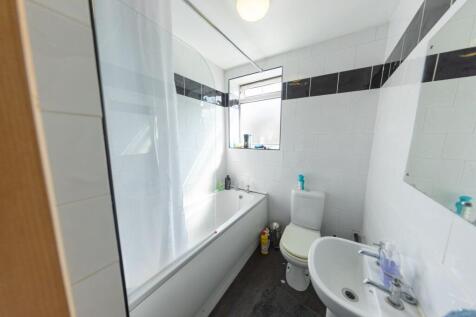 Bright and clean bathroom with a bathtub, a sma...