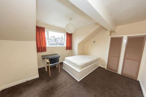 A cozy double bedroom with a large window provi...