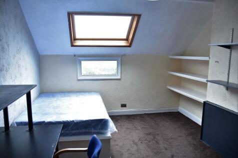 A cozy bedroom with a sloped ceiling featuring ...