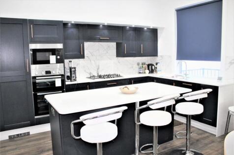 Modern kitchen with sleek black cabinetry, a wh...
