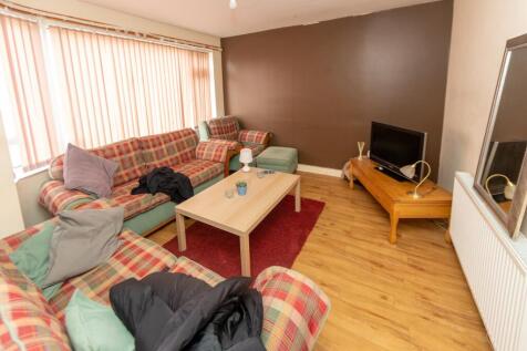 A cozy, well-lit living room featuring patterne...