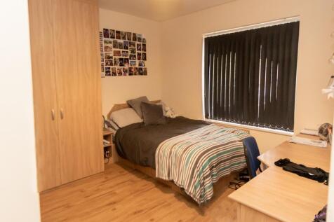 A cozy double bedroom featuring a large bed wit...